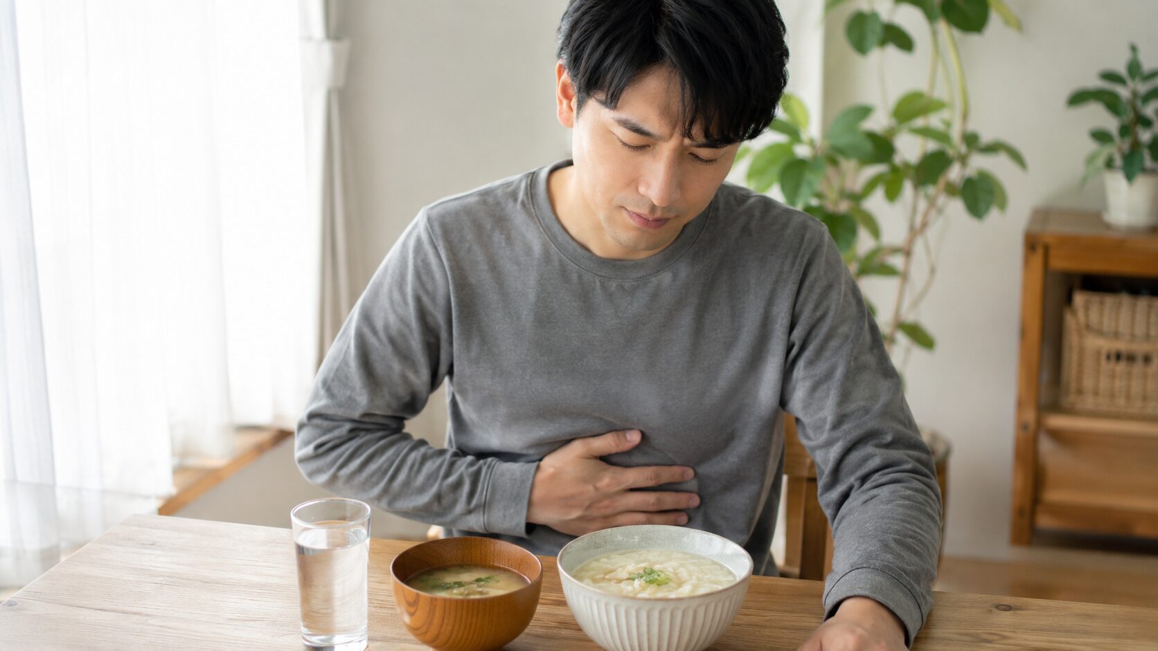 胃痛がある日にラーメンを避けて水分補給と軽い食事を選ぶ日本人男性